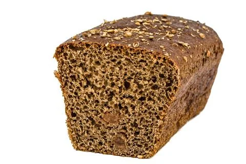 Cut in half a loaf of bread made of dark flour, isolated on white background Stock Photos