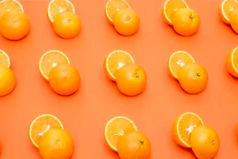 Cut in half oranges arranged in a row on an orange background Stock Photos