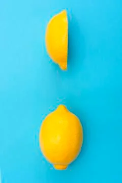 Cut in half pieces of yellow lemon and a whole yellow lemon Stock Photos