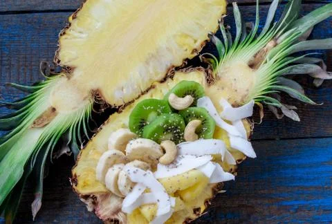 Cut in half pineapple with coconut, chia, kiwi, cashew. Stock Photos