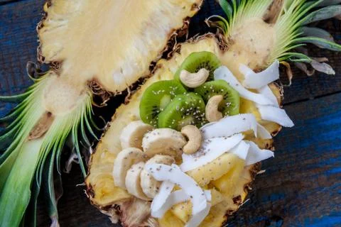 Cut in half pineapple with coconut, chia, kiwi, cashew. Stock Photos