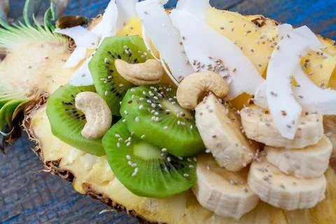 Cut in half pineapple with coconut, chia, kiwi, cashew. Stock Photos