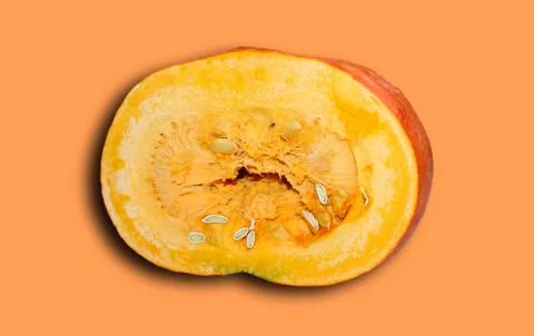 Cut off half of a pumpkin with a shadow isolated on an orange background. Stock Photos