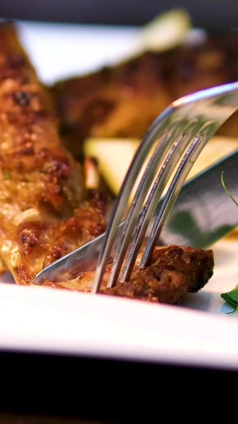 Cut with a knife and fork grilled crucian carp Appetizing fried crucian fish Stock Footage 323529710
