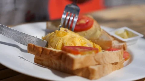 Cut with a knife and fork omelette on a plate with toast. 3840x2160. 4k Video stock 92404559