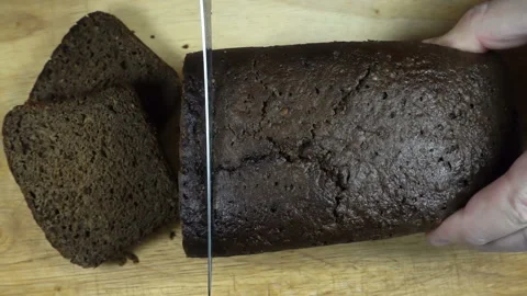 Cut a knife brown bread in slow motion. View from above Stock Footage 132160097