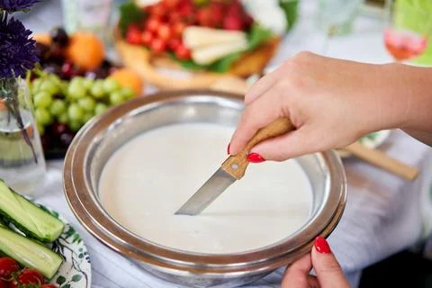 Cut with a knife, separate the serum. Master class and cheese tasting. Women Stock Photos