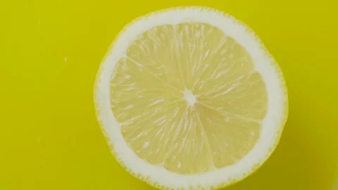 The cut lemon rotating on a yellow background Vídeo Stock 72531625