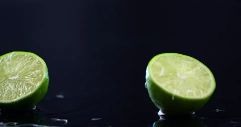 Cut lime falls on a wet surface and falls into two parts Stock Footage 152094487
