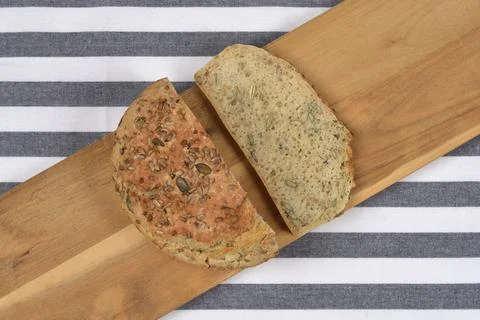 Cut Loaf and Slice of Seeded Whole Grain Bread on Wooden Board Stock Photos