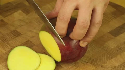 Cut mango with a sharp knife on a wooden board Stock Footage 189971786