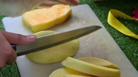 Cut the mango using a knife on a cutting board Stock Footage 267681120