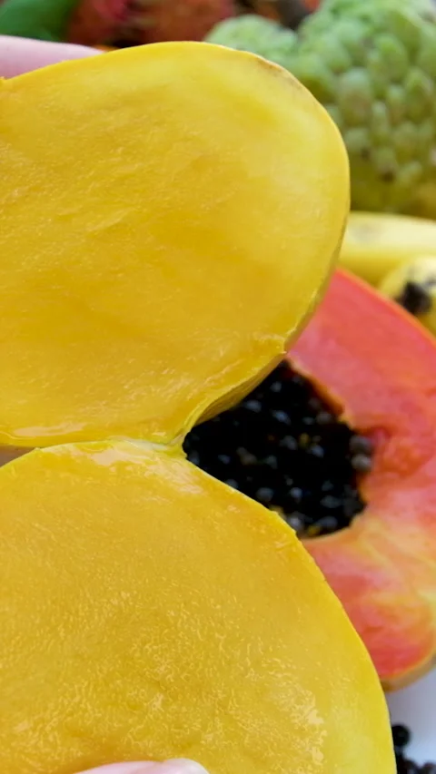 Cut mango woman hand cuts ripe mango into cubes on a white plate with a sharp Stock Footage 293502364