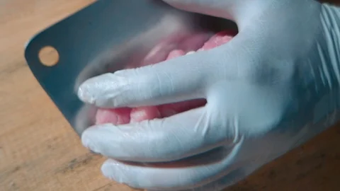 Cut meat by big kitchen knife dip into pot with warm water to continue Video stock 120409330