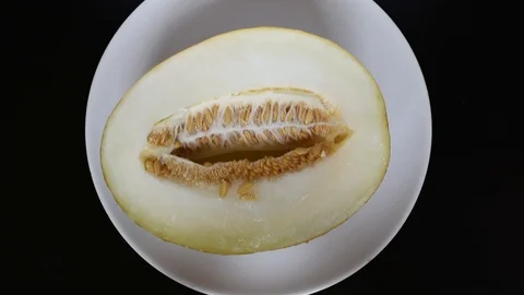 The cut melon lies on a white background on a dark table Video stock 96186822