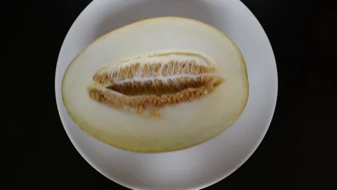 The cut melon lies on a white background on a dark table Stock Footage 96186839