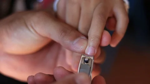 Cut the nails of the kid. Video stock 106970356