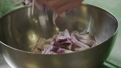 Cut onion being poured in a large bowl Stock Footage 129016435