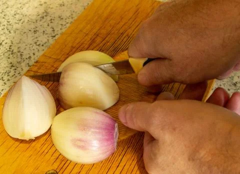Cut onions on a cutting Board with a knife. Stock Photos