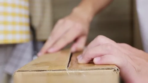 Cut open delivery parcel with knife. Unpack cardboard box using cutting tool. Stock Footage 344831501