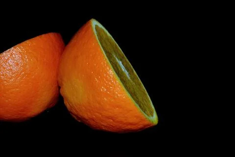 A cut orange on a black background. Stock-Fotos