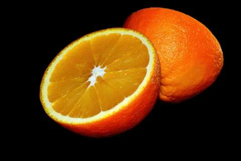 A cut orange on a black background. Stock-Fotos