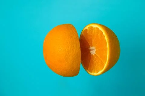 Cut orange on blue background Stock Photos