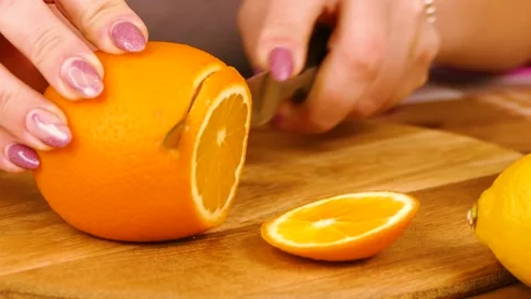Cut An Orange Into Slices on a plank Stock Footage 233620695