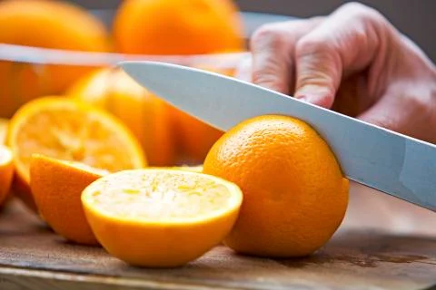 Cut oranges with knife on table Stock Photos