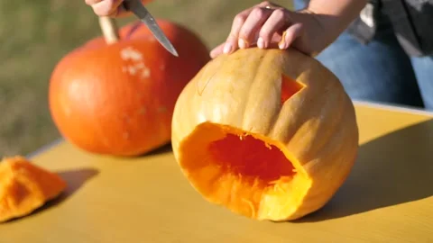 Cut out the eyes in the pumpkin. triangular pumpkin eyes Video stock 253218039