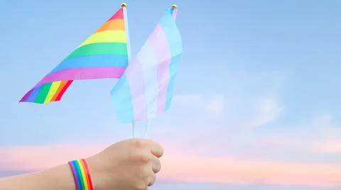 Cut out of hand holding both the LGBT flag and the LGBTQIA flag, set agains.. Stock Photos