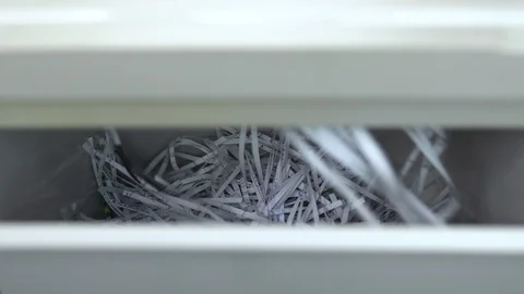 Cut paper falls into the container. Shredder destroys paper close-up. Shredder Stock Footage 117692369