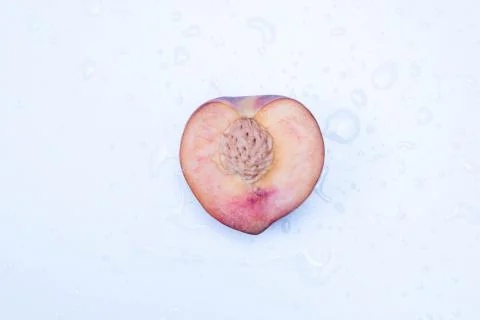 Cut peach in half lies on a table Stock Photos