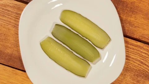 Cut pickled cucumber on white plate Video stock 73835335