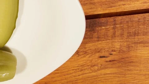 Cut pickled cucumber on white plate Video stock 73835629