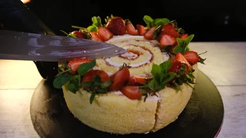 Cut a piece of cake from a sponge cake with cream decorated with strawberries Stock Footage 194736195