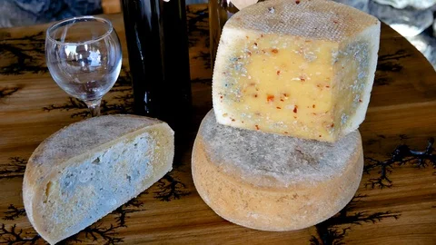 Cut Off A Piece Of Cheese With Mold With Bottle Of Red Wine And A Glass On Table Stock Footage 102957935