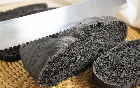 Cut into pieces of black bread with the addition of activated carbon, there i Stock-Fotos