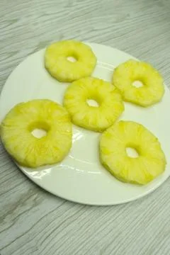 Cut a pineapple on a platter isolated on a white background . Stock Photos