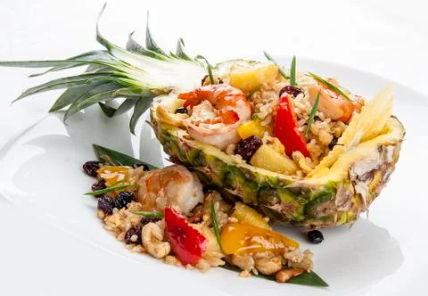 Cut pineapple stuffed with rice and Royal shrimps. On white background Stock Photos