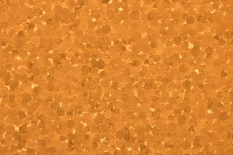 A cut of polystyrene foam is an orange texture. Bright background for designe Stock Photos