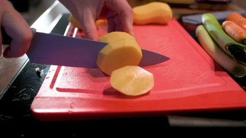 Cut the potato with a knife on a chopping board Stock Footage 124678243
