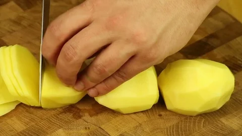 Cut potatoes with a sharp knife on a wooden board Stock Footage 83261677