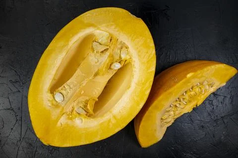 Cut pumpkin on black stone table, top view, slice of fresh pumpkin Stock Photos