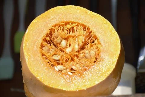 Cut pumpkin close-up. the vegetable pulp and seeds are clearly visible Stock Photos