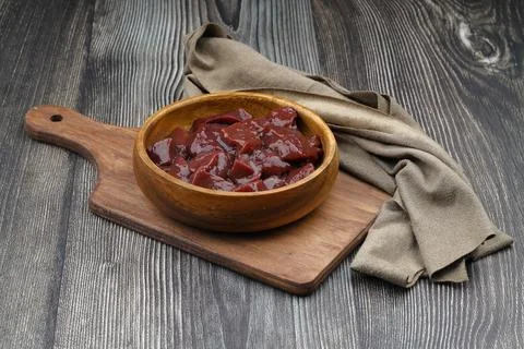 Cut raw beef liver with onions, spices, chili peppers and dill on wooden ta.. Stock Photos