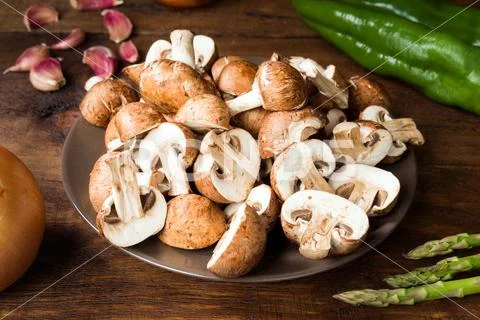 Cut raw mushrooms and other ingredients on rustic wood Stock Photos