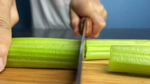 Cut raw organic celery slice on a wooden chopping board close up shot. Stock Footage 234201247