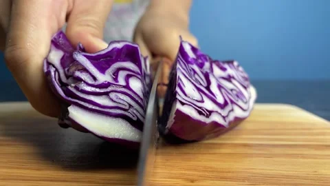 Cut raw red cabbage slice on a wooden chopping board at home kitchen close up Stock Footage 234034923