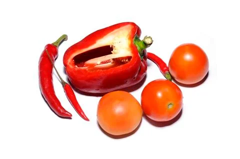 Cut red bell pepper, fresh tomatoes and chillies isolated on white background Stock Photos